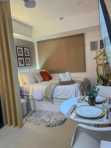 a bedroom with a bed with a table and a tableablish at Emetheria Residence CDO in Cagayan de Oro