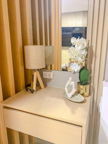 a dressing table with a lamp and a mirror at Emetheria Residence CDO in Cagayan de Oro