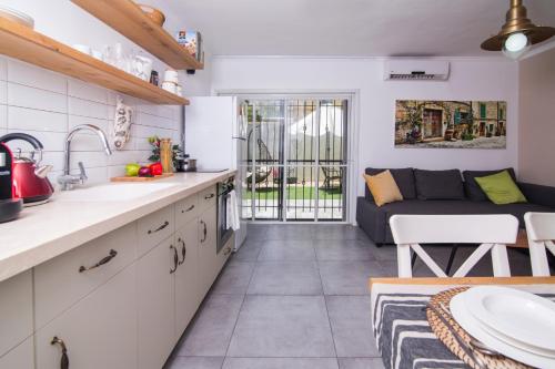 a kitchen and living room with a couch at HaBaitBe Matityahu By Domus in Beer Sheva