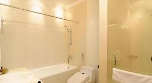 une salle de bain blanche avec toilettes et douche dans l'établissement Yusro Hotel Restaurant & Convention, à Peterongan