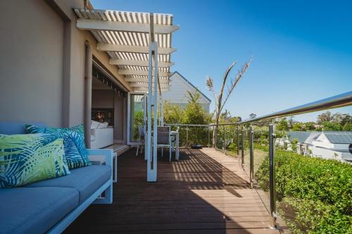 a patio with a blue couch on a deck at Palms Manor on Kingswood Golf Estate in George