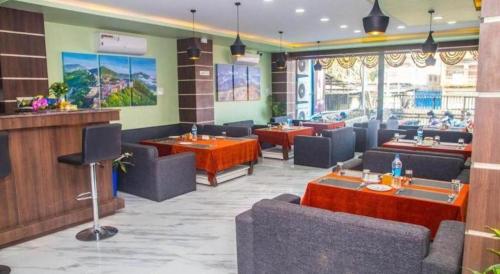 un restaurant avec des canapés et des tables dans une pièce dans l'établissement Hotel Gajur Palace, à Dharān Bāzār