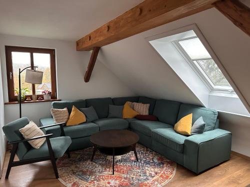 a living room with a green couch and a table at Ferienwohnung Lichterhof in Sebnitz
