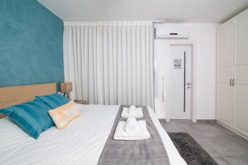 a bedroom with a bed with two towels on it at HaBaitBe Matityahu By Domus in Beer Sheva