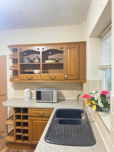 a kitchen with a sink and a microwave at Lodge near Merry Hill Shopping centre in Delph