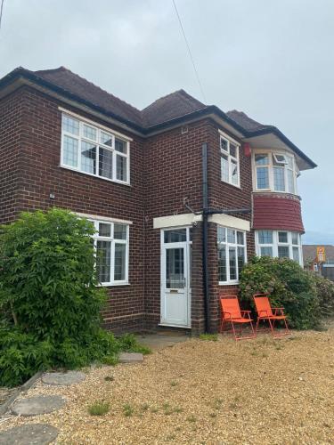 a brick house with two chairs in front of it at Lodge near Merry Hill Shopping centre in Delph