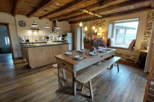 een keuken met een houten tafel in een kamer bij Gîte 8 pers avec jacuzzi et jardin Aurillac in Arpajon-sur-Cère