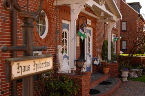 a brick house with a street sign in front of it at Hotel-Pension Haus Hubertus in Borkum