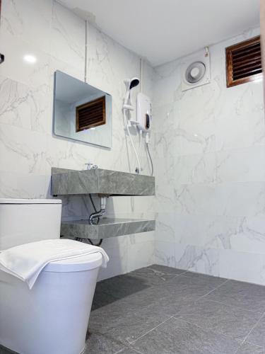ein weißes Badezimmer mit Toilette und Waschbecken in der Unterkunft Mini Vangvieng Resort in Vang Vieng