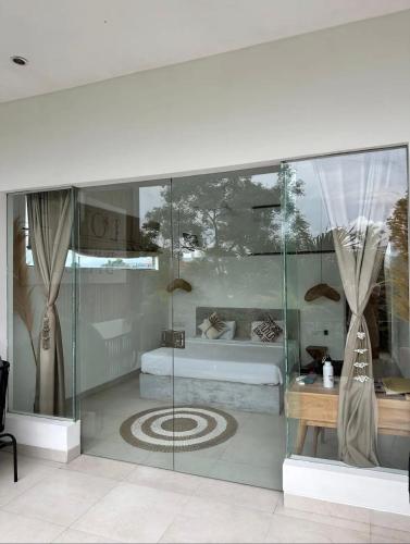 a glass room with a bed and a table at Luxus Villa Jungle View 3br in Tumbak Bayuh