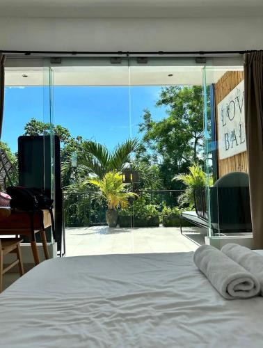a bedroom with a bed and a large glass window at Luxus Villa Jungle View 3br in Tumbak Bayuh