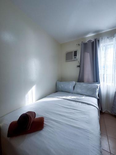 a bedroom with a large white bed and a window at Modern 2BR Escape Overlooking the Iloilo River in Mandurriao