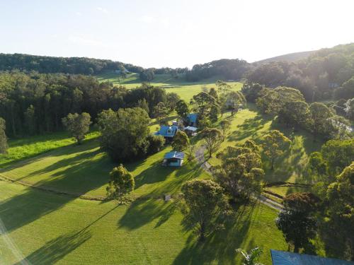 an aerial view of a farm with a field and trees at THE MAINSTAY FARMSTAY Unique Aussie Farmstay, Seal Rocks, Barrington Coast in Neranie