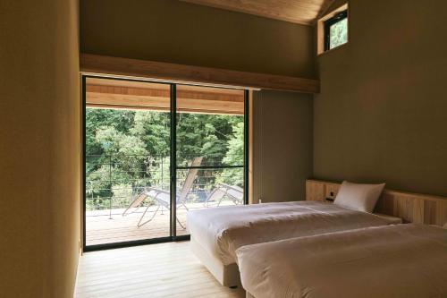 a bedroom with two beds and a large window at GEOSPOT Motohakone A 2025年10月 New Open in Hakone