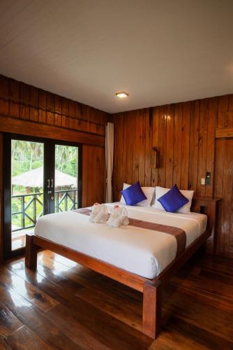a bedroom with a large white bed with blue pillows at COCO Canopy Boutique Resort in Ko Jum