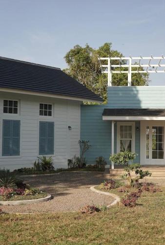 a blue and white house with a yard at Dirumahbandung in Sarireja