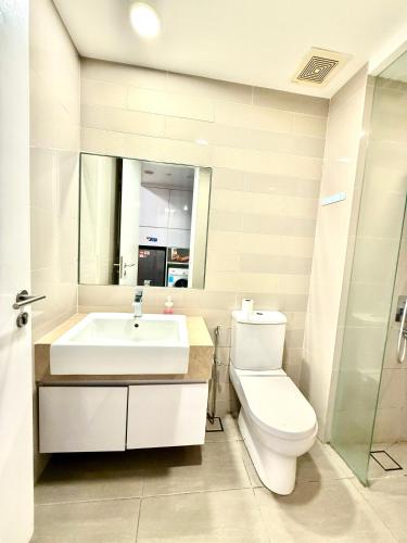 a bathroom with a sink and a toilet and a mirror at Crystal Suites at Ramad KLCC in Kuala Lumpur