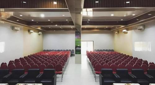 an empty room with red chairs in a building at Flamengo Hotel in Gedeg