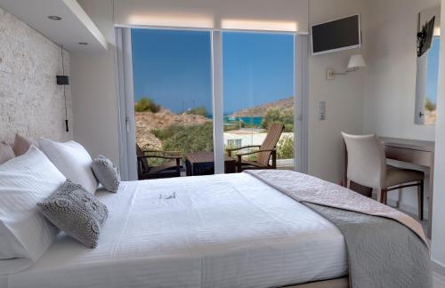 ein Schlafzimmer mit einem großen weißen Bett und einem Balkon in der Unterkunft Elounda Spa Villa Crete - Ultimate Luxury Resort in Elounda