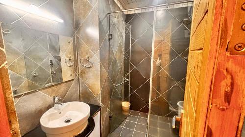 Un pequeño baño con lavabo y ducha. en Rajmahal Inn Dalhousie, en Dalhousie