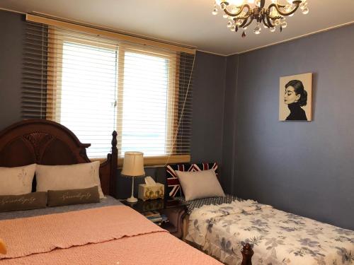 Un dormitorio con dos camas y una lámpara de araña. en sunset, en Jeonju