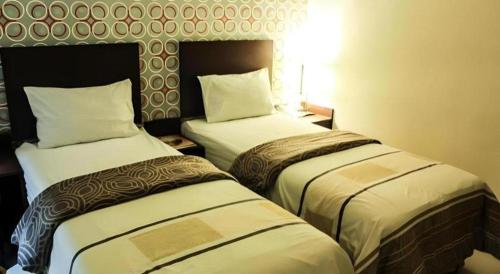 a hotel room with two beds in a room at Vindhika Hotel in Makassar
