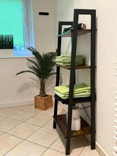 a black shelf with towels on it in a bathroom at Eigentumswohnung in Dresden in Dresden