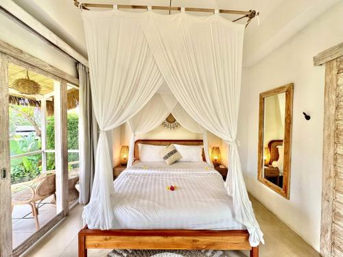 a bedroom with a bed with a canopy at Hot Stone Club Ubud in Ubud