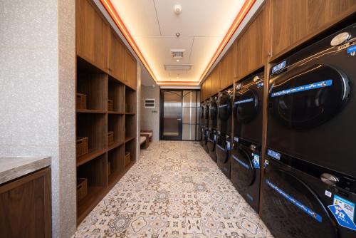 a laundry room with a washer and dryer at Nostalgia S Hotel Beijing Qianmen Street & Tianqiao Performing Arts Center 时光漫步S酒店 北京前门天桥艺术中心店 Free fresh ground coffee,Free laundry service in Beijing