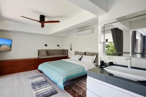 a white bedroom with a bed and a sink at Magic suites Seaview villas, Koh Samui in Choeng Mon Beach