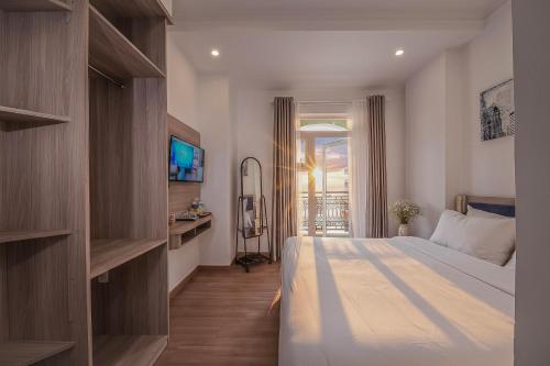 une chambre avec un grand lit et une télévision dans l'établissement Bee Luxury Dalat Hotel, à Đà Lạt