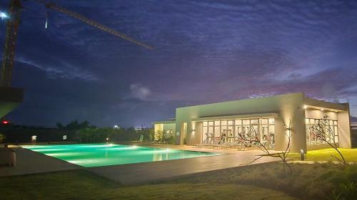 a building with a swimming pool at night at Elandor Suite East Minissy Moka in Moka
