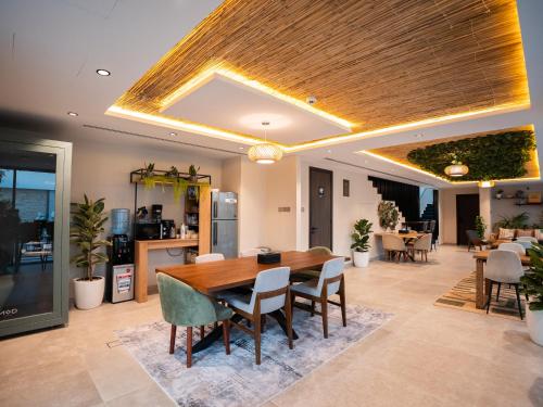 a dining room with a wooden table and chairs at Nas House Private & Shared Villas in Dubai