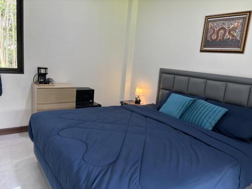 クラビタウンにあるYour Red Earth Homestayのベッドルーム(青いベッド1台、青い毛布付)