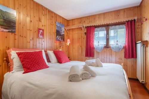 a bedroom with a large white bed with red pillows at La Baita Verde in Motta