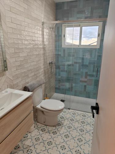 a bathroom with a toilet and a sink and a shower at Villa Bellavista in Olvera
