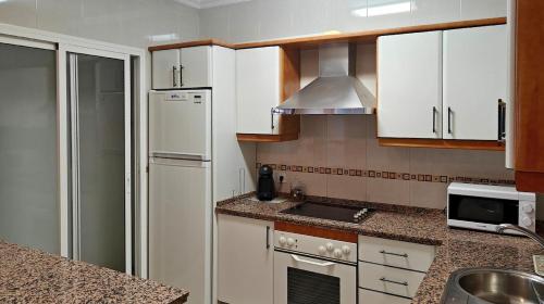 een keuken met witte kasten en een witte koelkast bij Villa Bellavista in Olvera