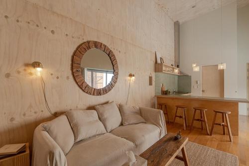 Sinŏm-niにあるJeju Mooi Pensionのソファと鏡のあるリビングルーム