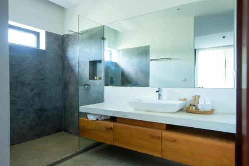 a bathroom with a sink and a glass shower at K.K inn Boutique Siem Reap in Siem Reap