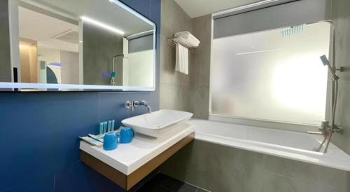 Ban Si ThanにあるGlacier Hotel Khon Kaenの白い洗面台と鏡のあるバスルーム