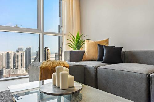 un salon avec un canapé et une grande fenêtre dans l'établissement Silkhaus Stylish 2BDR Stay in Radiant Boulevard, à Mushayrib