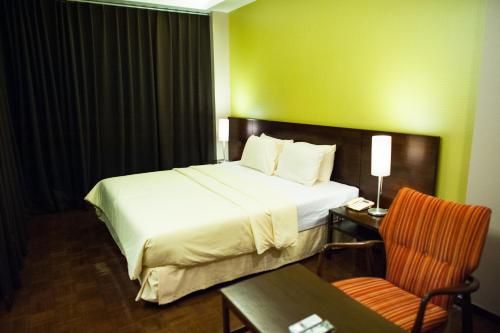 una camera d'albergo con letto, tavolo e sedia di Baansilom Soi 3 a Bangkok