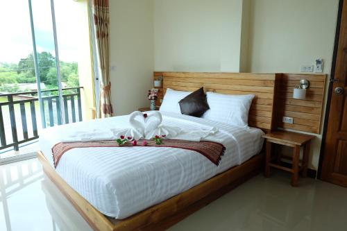 a bedroom with a bed with two swans on it at Chatin Guesthouse in Khao Lak