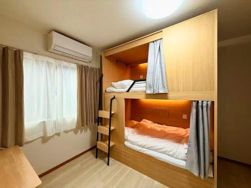 a room with two bunk beds and a window at 晴天ハイム in Kokubunji