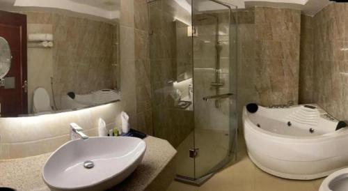 un bagno con vasca, lavandino e doccia di Hotel Tower Inn, Chittagong a Chittagong Port