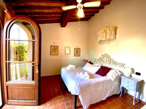 a bedroom with a bed and a large window at Podere Borgaruccio in Peccioli