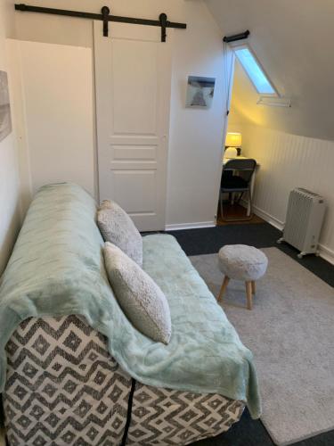 a bedroom with a bed with a blanket and pillows at 45 Grande Rue bis in Ault