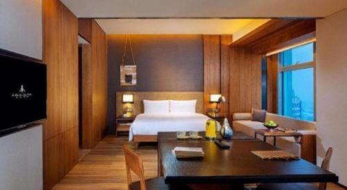 a hotel room with a bed and a dining table at AOLUGUYA in Harbin