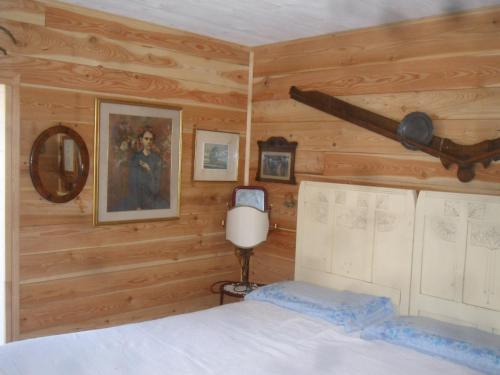a bedroom with wooden walls and a bed with a ceiling at La vieille maison Biselli in Tende
