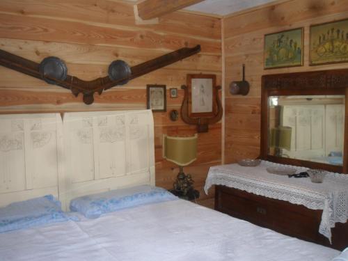 une chambre avec deux lits et un miroir dans l'établissement La vieille maison Biselli, à Tende